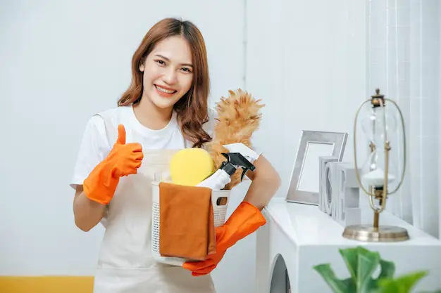 portrait-young-pretty-woman-apron-rubber-gloves-holding-basket-cleaning-equipment-hand-she-smile-thump-up-looking-camera-copy-space_1150-48124